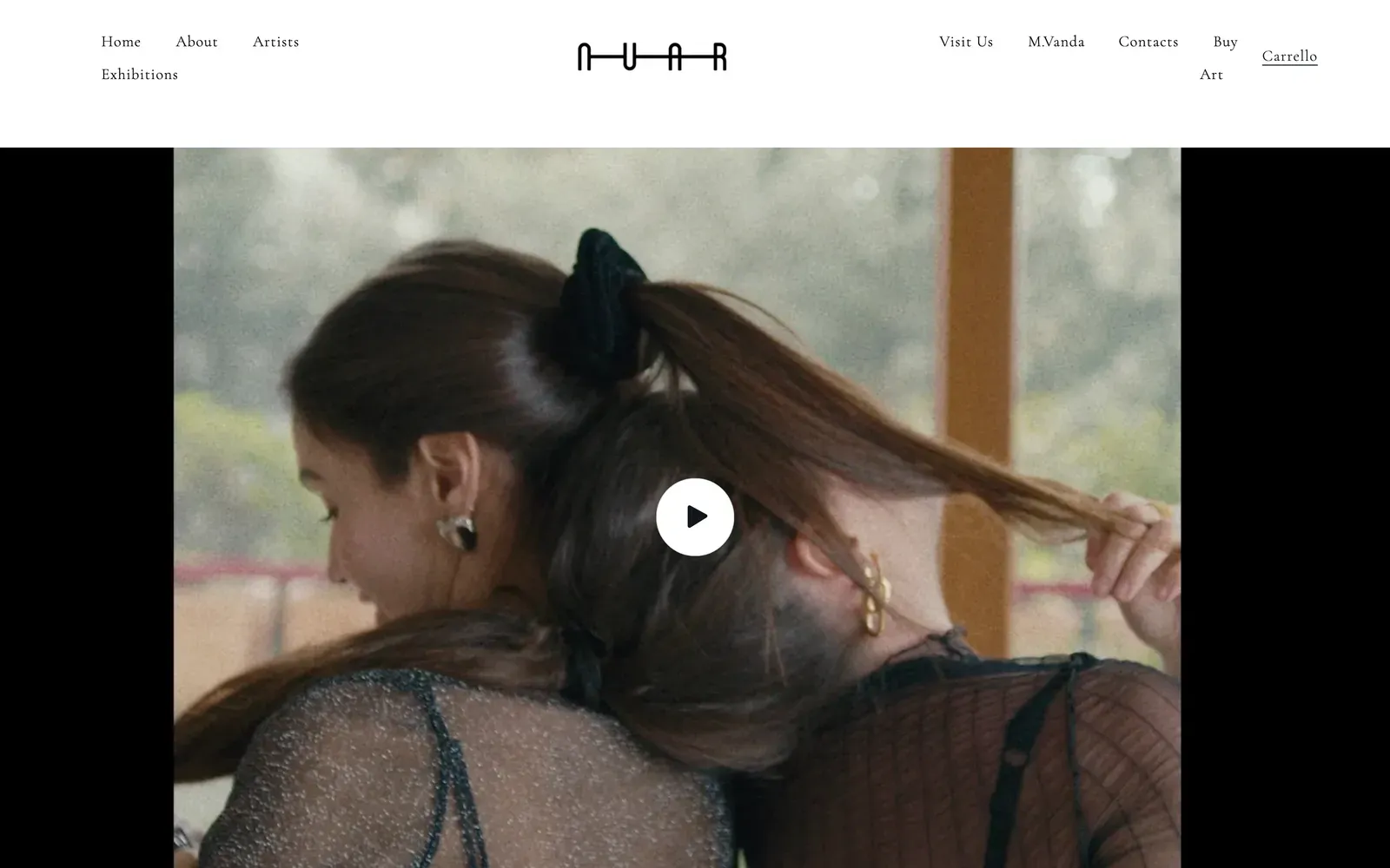 Home de la tienda Shopify de Nuar Gallery en nuargallery.com: navegación minimalista con serifa alrededor del logo N-U-A-R sobre un hero de vídeo de dos mujeres abrazándose